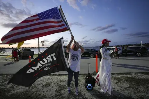 Trang Le of Orlando, right, and Maria Korynsel of North Palm Beach show their support for former President Donald Trump after the news broke that Trump has been indicted by a Manhattan grand jury, Thursday, March 30, 2023, near Trump's Mar-a-Lago estate in Palm Beach, Fla. (AP Photo/Rebecca Blackwell)