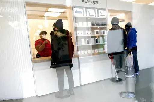Customers pick up online orders at the Apple Store at the Towson Town Center, Dec. 15, 2020, in Towson, Md.  Apple store employees in the Baltimore suburb voted to unionize by a nearly 2-to-1 margin on Saturday, June 18, 2022. (AP Photo/Julio Cortez, file)