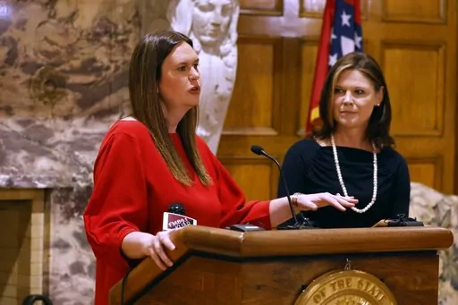 Arkansas Gov. Sarah Huckabee Sanders, left, and Kristi Putnam, secretary of the Arkansas Department of Human Services, right, announce the state would seek federal approval to require ARHOME participants to work, volunteer or enroll in classes, on Wednesday, Feb. 15, 2023, at the state Capitol in Little Rock, Ark. (Thomas Metthe/The Arkansas Democrat-Gazette via AP)