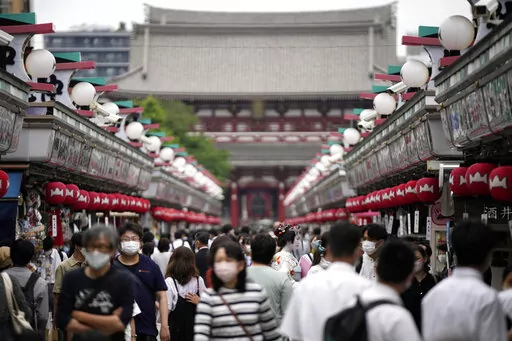 Visitors walk along a shopping street at the Asakusa District, Friday, June 10, 2022, in Tokyo. The dollar is near its highest level in more than two decades against a key index measuring six major currencies, including the euro and Japanese yen. (AP Photo/Eugene Hoshiko, File)