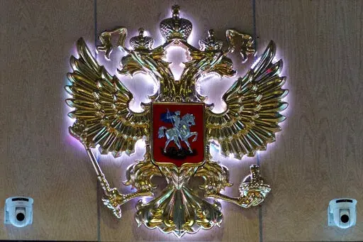 The emblem for the Russian Defense Ministry is displayed at the ministry building in Moscow, Russia on Monday, Sept. 26, 2016. On Saturday, Oct. 15, 2022, the ministry said two men fired at troops at a Russian military firing range near Ukraine, killing 11 and wounding 15 others, before getting killed. (AP Photo/Ivan Sekretarev, File)