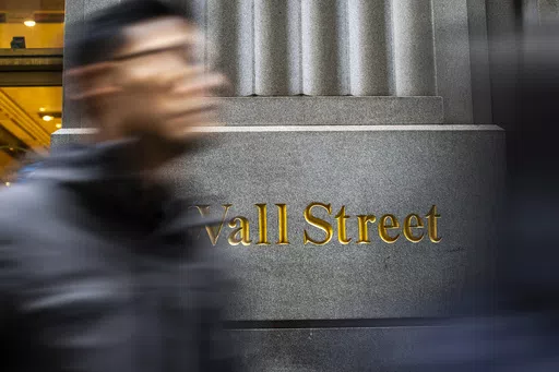 People walk on Wall St. near the New York Stock Exchange in New York, March 19, 2024. Know you should be investing but can’t quite bring yourself to do it? Feeling nervous about investing and other financial tasks is normal, but in some cases, it can be the result of financial trauma or abuse. (AP Photo/Eduardo Munoz Alvarez, File)