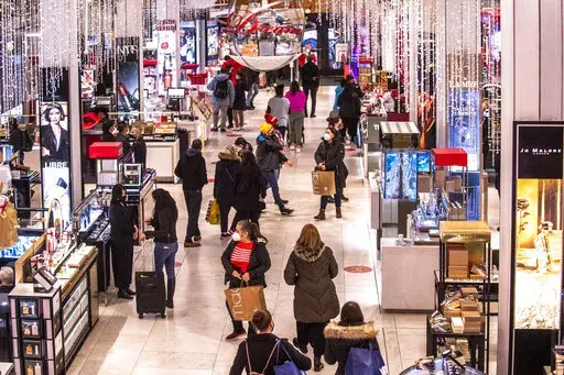 Shoppers walk through Macy's  on Nov. 26, 2021, in New York.  Americans slowed their spending from November to December as a trifecta of product shortages, surging prices and a surge of the highly contagious omicron curtailed spending. Retail sales fell 1.9% in December compared with the previous month when sales increased 0.3%, the U.S. Commerce Department said Friday, Jan. 14, 2022. (AP Photo/Brittainy Newman, File)