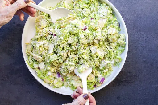 A recipe for Creamy Brussels Sprouts Slaw, with a mayonnaise-based dressing spiked with citrus juice, onions, mustard, and Parmesan cheese, appears in New York in January 2018. (Carrie Crow via AP)