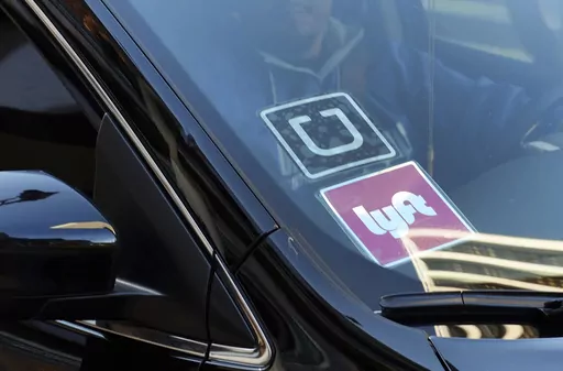 In this Jan. 12, 2016, file photo, a ride share car displays Lyft and Uber stickers on its front windshield in downtown Los Angeles. A California appeals court ruled Monday, March 13, 2023, that a voter-backed initiative exempting Uber and Lyft from a key provision of state employment law is constitutional, a reversal of a lower court decision that marks a win for the ride-hailing giants. (AP Photo/Richard Vogel, File)