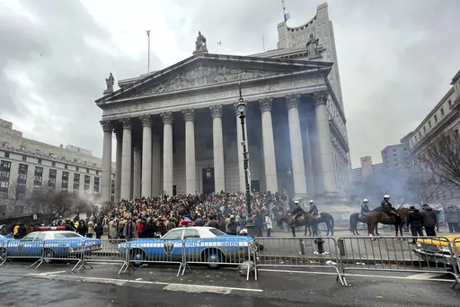 Throngs of actors portraying protesters, some in make-up, gather outside a courthouse for the filming of a scene in the "Joker" movie sequel in New York, Saturday, March 25, 2023. Production crews had to wrestle with the possibility that filming could be disrupted by real-life protests over the Trump case, none of which have materialized so far. (AP Photo/Bobby Caina Calvan)