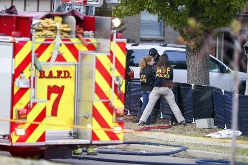 Police and firefighters investigate the scene of a house fire with multiple fatalities in Broken Arrow, Okla., outside Tulsa, Thursday, Oct. 27, 2022. Eight people were found dead after the fire was extinguished and police said they were investigating the deaths as homicides. (Ian Maule/Tulsa World via AP)
