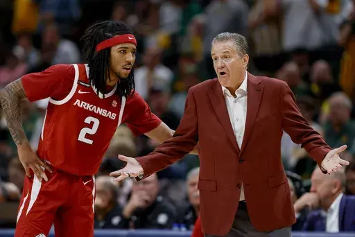 Arkansas guard Boogie Fland (2) and head coach John Calipari, right, talk between plays during the second half of an NCAA college basketball game against Baylor, Saturday, Nov. 9, 2024, in Dallas. (AP Photo/Gareth Patterson)