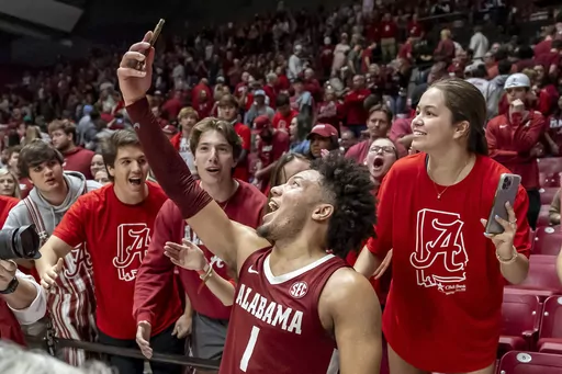 Alabama guard Mark Sears (1) takes a selfie as he celebrates with the student section after Alabama's overtime win over Arkansas in an NCAA college basketball game, Saturday, March 9, 2024, in Tuscaloosa, Ala. (AP Photo/Vasha Hunt)