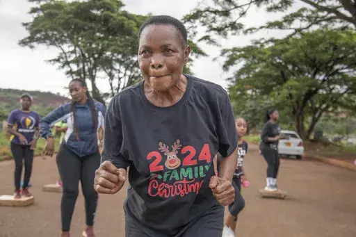 Mellisa Sachitongo, 65, exercises with the Commandos Fitness Club at the Warren Hills cemetery in Harare, Zimbabwe, Saturday, Jan. 18, 2025. ( AP Photo/Aaron Ufumeli)