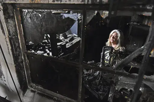 Jennifer Williams, a three-year volunteer for Cockrill's Country Critters, looks around the reptile room Friday, Feb. 25, 2022, where a fire started before spreading through the rest of the exotic barn Thursday in Austin. (Staci Vandagriff/The Arkansas Democrat-Gazette via AP)