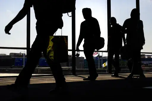 Arriving passengers move toward the baggage claim area at Philadelphia International Airport in Philadelphia on Friday, July 1, 2022. Travelers will probably pay more for airline tickets or a hotel room around the holidays than they did over last Thanksgiving or Christmas. (AP Photo/Matt Rourke, File)