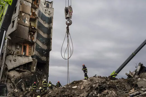 Firefighters work on a destroyed apartment building in the town of Borodyanka, Ukraine, on Saturday, April 9, 2022. Russian troops occupied the town of Borodyanka for weeks. Several apartment buildings were destroyed during fighting between the Russian troops and the Ukrainian forces in the town around 40 miles northwest of Kiev. (AP Photo/Petros Giannakouris)
