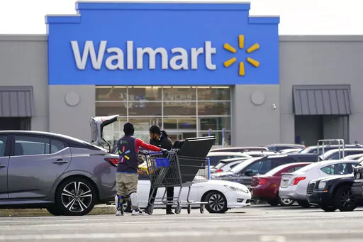 A Walmart employee helps a customer outside the Walmart store in Philadelphia, Wednesday, Nov. 17, 2021.  Walmart reported stronger sales for the fiscal first quarter, Tuesday, May 17, 2022,  but its profits took a beating as the nation’s largest retailer grappled with surging inflation on food and fuel and higher costs from a still snarled global supply chain.  (AP Photo/Matt Rourke, File)