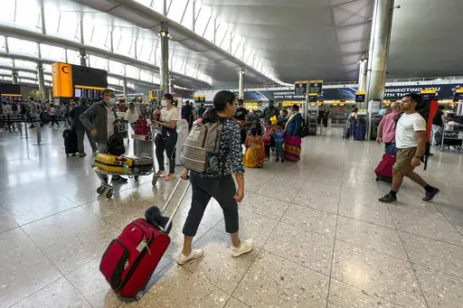 Travelers at Heathrow Airport in London, Wednesday, July 13, 2022. Heathrow Airport said Thursday, Aug. 11, 2022, that its limit on the number of passengers is easing a travel crunch that has led to flight cancellations and lost luggage as soaring demand for summer trips runs up against pandemic-era staffing shortages. (AP Photo/Alberto Pezzali, File)