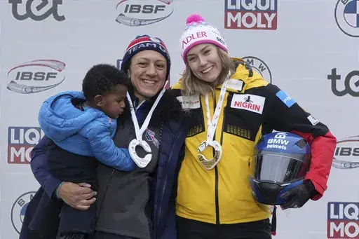 From left, third placed Elana Meyers Taylor of USA and Laura Nolte of Germany celebrate on the podium during the award ceremony of the Women's Monobob World Cup race in Sigulda, Latvia, Saturday, Feb. 3, 2024. (AP Photo/Oksana Dzadan)