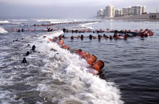 U.S. Navy SEAL candidates, participate in "surf immersion" during Basic Underwater Demolition/SEAL (BUD/S) training at the Naval Special Warfare (NSW) Center in Coronado, Calif., on May 4, 2020. A Navy SEAL candidate who died just hours after completing the grueling Hell Week test was identified Sunday, Feb. 6, 2022, as a 24-year-old sailor who joined the military last year. The U.S. Navy said that Seaman Kyle Mullen died at a San Diego area hospital on Friday, Feb. 4, after he and another SEAL 