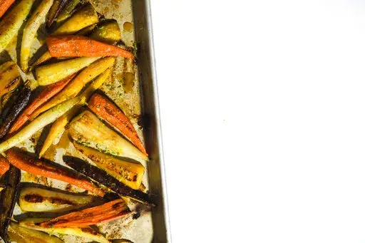 This image released by Milk Street shows a recipe for roasted carrots with the turmeric-infused honey. (Milk Street via AP)