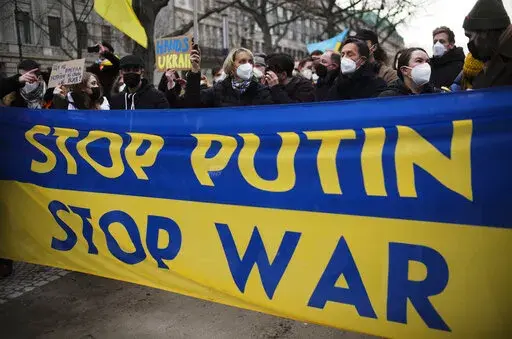 Demonstrators march along the street near the Russian embassy to protest against the escalation of the tension between Russia and Ukraine in Berlin, Germany, Tuesday, Feb. 22, 2022. Russian President Vladimir Putin has asked the country’s parliament for permission to use military force outside the country. That could presage a broader attack on Ukraine after the U.S. said an invasion was already underway there. (AP Photo/Markus Schreiber)