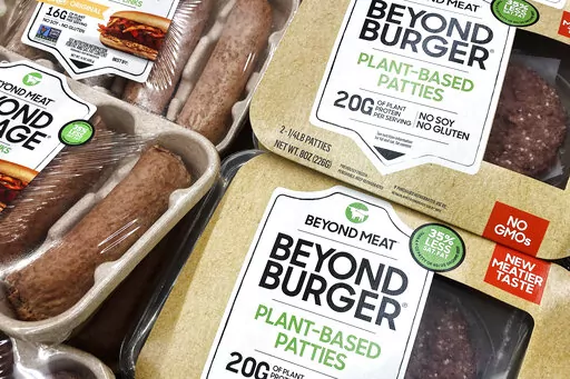 Beyond Meat products are seen in a refrigerated case inside a grocery store in Mount Prospect, Ill., Saturday, Feb. 19, 2022.  Beyond Meat is cutting about 200 jobs and lowering its full-year revenue outlook as the plant-based meat maker attempts to reduce expenses and become cash flow positive. The company said Friday, Oct. 14,  the job cuts, which amount to approximately 19% of its total global workforce, will be mostly completed by the end of the year.  (AP Photo/Nam Y. Huh, File)