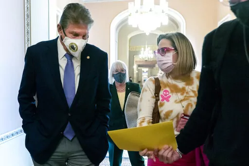 Sen. Joe Manchin, D-W.Va., left, walks with Sen. Kyrsten Sinema, D-Ariz., with Sen. Patty Murray, D-Wash., behind them at center, after attending a Democratic policy luncheon, on Nov. 16, 2021, on Capitol Hill in Washington. While Manchin and Sinema’s opposition to changing Senate rules stalled the party's signature voting legislation this month, they have been reliable votes on President Joe Biden's nominees to the courts. The two Democratic senators will be the center of attention as Biden 