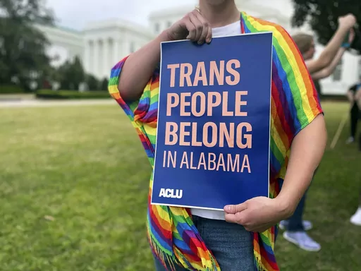 A person holds up a sign reading, "Trans People Belong in Alabama," during a rally outside the Alabama Statehouse in Montgomery, Ala., on International Transgender Day of Visibility, Friday, March 31, 2023. Alabama can begin immediately enforcing a ban outlawing the use of puberty blockers and hormones to treat transgender people under 19, a federal appeals court ruled Thursday, Jan. 11, 2024, granting the state’s request to stay a preliminary injunction that had blocked enforcement of the 202