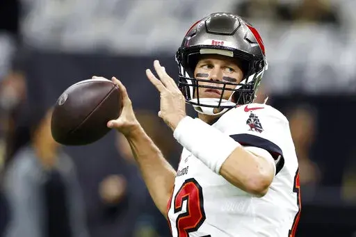 Tampa Bay Buccaneers quarterback Tom Brady warms up before the first half of an NFL football game against New Orleans Saints in New Orleans, Sunday, Sept. 18, 2022. In some Tampa Bay area schools, students use foam rollers and vibrating spheres to massage their muscles as they work toward goals for strength and flexibility. It's all part of a new physical education curriculum from Brady, whose vision for healthy living is fueling a fitness empire. (AP Photo/Butch Dill, File)