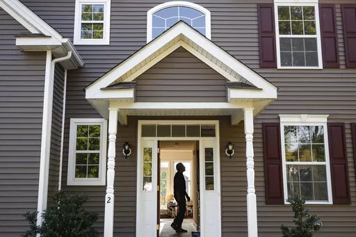 FILE - In this July 21, 2020, file photo, a homeowner tours their new home, in Washingtonville, N.Y. In addition to the new year bringing confetti and a fresh calendar, it’s a time to set big money goals for the next 12 months. That might mean finally paying off debt, buying a house or taking a long-delayed vacation.  (AP Photo/John Minchillo, File)