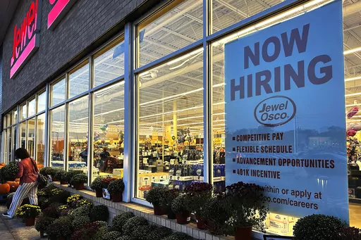 A hiring sign is displayed at a grocery store, Oct. 5, 2023, in Deerfield, Ill. Most business economists think the U.S. economy could avoid a recession in 2024, even if the job market ends up weakening under the weight of high interest rates, according to a survey released Monday, Dec. 4. (AP Photo/Nam Y. Huh, File)