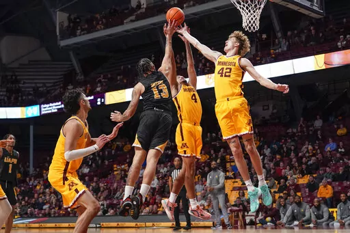 Arkansas-Pine Bluff forward Chris Greene (13), Minnesota guard Braeden Carrington (4) and center Treyton Thompson (42) reach for a rebound during the second half of an NCAA college basketball game on Wednesday, Dec. 14, 2022, in Minneapolis. Minnesota won 72-56.(AP Photo/Craig Lassig)