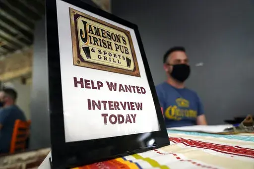 A hiring sign is shown at a booth for Jameson's Irish Pub during a job fair on Sept. 22, 2021, in the West Hollywood section of Los Angeles. California's unemployment rate has fallen to 5.4% after employers added a surprising 138,100 jobs in February. (AP Photo/Marcio Jose Sanchez, File)