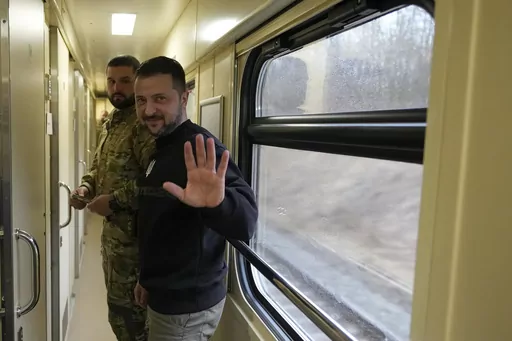 Ukrainian President Volodymyr Zelenskyy waves goodbye after an interview with The Associated Press on a train traveling from the Sumy region to Kyiv, Ukraine, Tuesday March 28, 2023. In the interview, Zelenskyy warned that unless his nation wins a drawn-out battle in the key eastern city of Bakhmut, Russia could begin building international support for a deal that could require Ukraine to make unacceptable compromises. (AP Photo/Efrem Lukatsky)