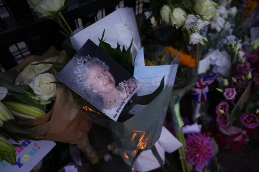 Messages, flowers and candles are seen at the gates of Buckingham Palace in London, Friday, Sept. 9, 2022. (AP Photo/Kirsty Wigglesworth)