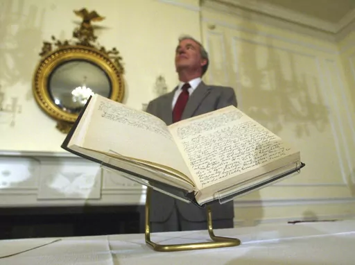 Archivist of the U.S John Carlin stands behind a 1947 Harry Truman presidential diary, July 10, 2003, at the National Archives in Washington. Presidents from George Washington to Joe Biden have kept presidential diaries. In them, they confide in themselves, express raw opinions, trace even the humdrum habits of their day and offer insight-on-the-fly on monumental decisions of their time. It's where they may also spill secrets they shouldn't. (AP Photo/Rick Bowmer, File)