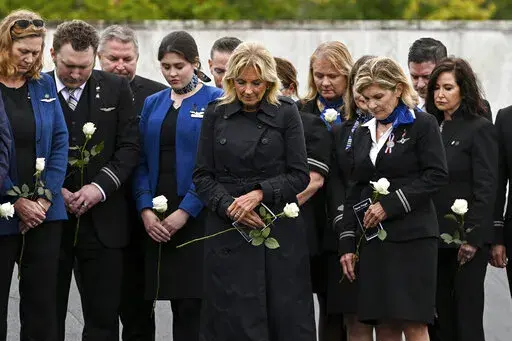 First lady Jill Biden participates in a moment of silence with the members of the Association of Flight Attendants at the Flight 93 National Memorial Wall of Names following a ceremony commemorating the 21st anniversary of the Sept. 11, 2001 terrorist attacks in Shanksville, Pa., Sunday, Sept. 11, 2022. (AP Photo/Barry Reeger)