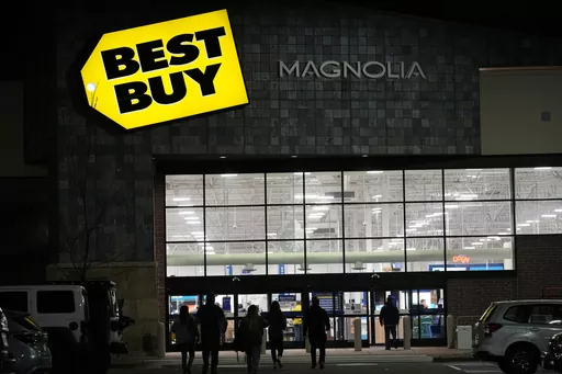 Shoppers are silhouetted as they walk toward a Best Buy store after doors opened at 5 a.m., Nov. 26, 2021, in Lone Tree, Colo. Best Buy is saying goodbye to movie-watching with physical discs. The consumer electronics retailer plans to phase out its DVD and Blu-ray sales by early 2024 — with physical movies set to be sold in-stores and online as they are today through the holidays. (AP Photo/David Zalubowski, file)