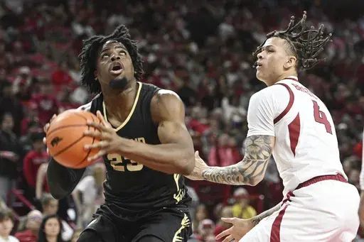 Oakland forward Allen Mukeba (23) tries to drive past Arkansas forward Trevon Brazile (4) during the first half of an NCAA college basketball game Monday, Dec. 30, 2024, in Fayetteville, Ark. (AP Photo/Michael Woods)