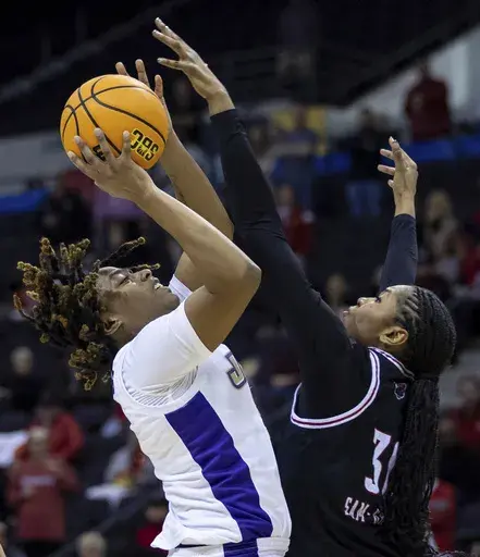 James Madison forward Ashanti Barnes, left, looks to shoot against Arkansas State forward Nissa Sam-Grant, right, during the second half of an NCAA college basketball game in the final of the Sun Belt Conference tournament in Pensacola, Fla., Monday, March 10, 2025. (Daniel Lin/Daily News-Record via AP)