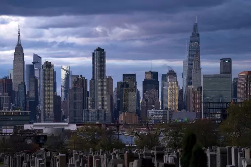 The sun sets behind the New York skyline, Nov. 13, 2022, as seen from Calvary Cemetery. New York City appears to have gotten an additional 1,090 people added to its population total recently after asking the Census Bureau to double-check the city's numbers from the head count of every U.S. resident, city officials said. (AP Photo/Julia Nikhinson, File)