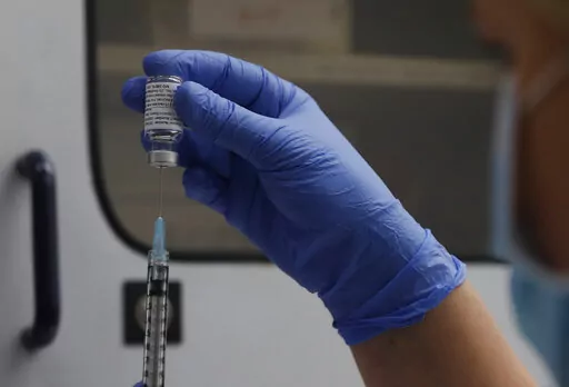A vial of the Phase 3 Novavax coronavirus vaccine is seen ready for use in the trial at St. George's University hospital in London, Oct. 7, 2020. The Novavax COVID-19 vaccine that could soon win federal approval may offer a boost for the U.S. military: an opportunity to get shots into some of the thousands of service members who have refused the vaccine for religious reasons. (AP Photo/Alastair Grant, File)