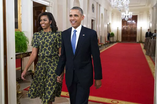 First lady Michelle Obama, and President Barack Obama arrive for the Presidential Medal of Freedom ceremony in the East Room of the White House, on Tuesday, Nov. 24, 2015, in Washington. Former President Barack Obama's presidential portrait will be unveiled at the White House in a Sept. 7, 2022, ceremony hosted by President Joe Biden. (AP Photo/Evan Vucci, File)