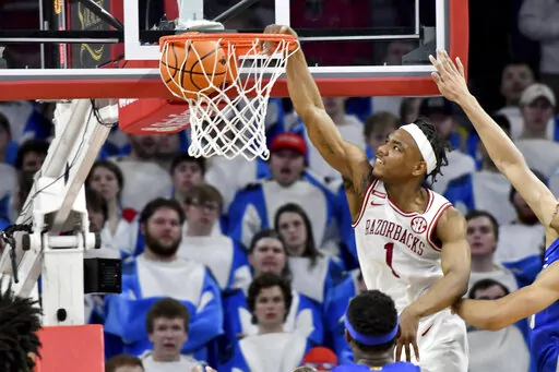 Arkansas guard JD Notae (1) dunks the ball over Kentucky defenders during the second half of an NCAA college basketball game Saturday, Feb. 26, 2022, in Fayetteville, Ark. (AP Photo/Michael Woods)