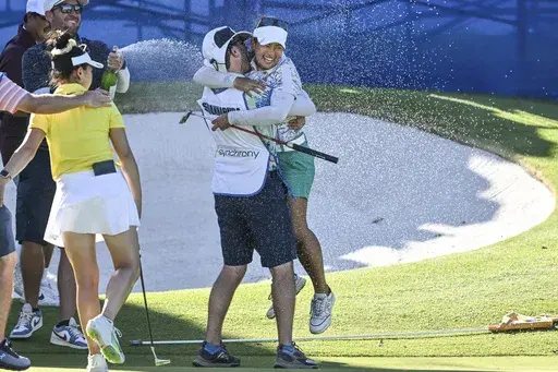 Jasmine Suwannapura, of Thailand, celebrates with her caddie and husband Mike Thomas after winning the LPGA Walmart NW Arkansas Championship golf tournament, Sunday, Sept. 29, 2024, in Rogers, Ark. (AP Photo/Michael Woods)