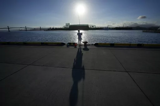 An angler fishes at Onahama Port in Iwaki, northeastern Japan, 68 kilometers (42 miles) from the Fukushima Daiichi nuclear power plant, damaged by a massive March 11, 2011, earthquake and tsunami, on Friday, Aug. 25, 2023. Fish auction prices at a port south of the Fukushima Daiichi nuclear power plant Friday somehow dipped amid uncertainty about how consumers may respond a day after release to sea of treated and diluted radioactive wastewater began despite protests at home and in neighboring co