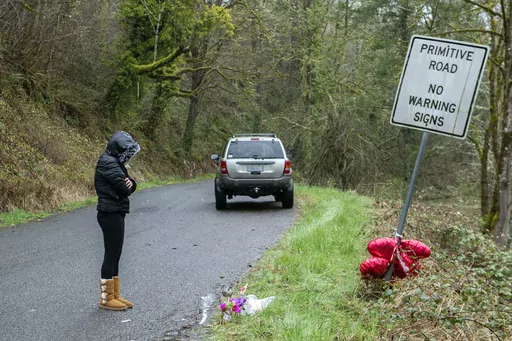 Brandy Pickard of Washougal, Wash., pauses to honor the memory of Meshay "Karmen" Melendez, 27, and her daughter, Layla Stewart, 7, along Wooding Road in Washougal, Wash., Thursday, May 23, 2023. The man named as a person of interest in the disappearance of his ex-girlfriend and her 7-year-old daughter was charged with two counts of murder in their deaths, police in Washington state said Friday, March 31, 2023. (Amanda Cowan/The Columbian via AP, File)