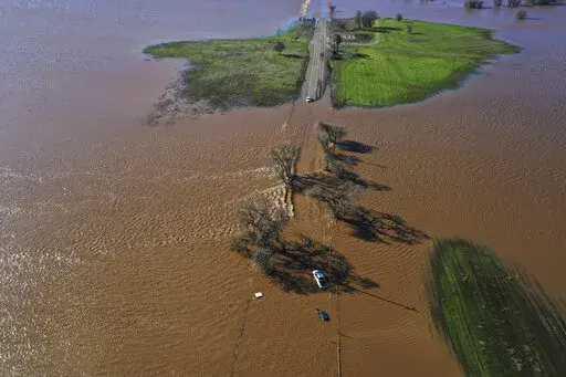 Three vehicles are submerged on Dillard Road west of Highway 99 in south Sacramento County in Wilton, Calif., Sunday, Jan. 1, 2023, after heavy rains on New Year's Eve produced levee breaks. Saturday's system was warmer and wetter, while storms this week will be colder, said Hannah Chandler-Cooley, a meteorologist at the National Weather Service in Sacramento. The Sacramento region could receive a total of 4 to 5 inches (10 to 13 centimeters) of rain over the week, Chandler-Cooley said. (Hector 