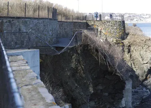 In this photo provided by Salve Regina University a collapsed portion of the iconic oceanside Cliff Walk shows exposed earth, below, near a stone wall, Thursday, March 3, 2022, in Newport, R.I. The walk is a major tourist draw offering breathtaking views of the ocean and Newport's famed Gilded Age mansions. There were no injuries reported. (Joseph L. Gugliuzza/Salve Regina University via AP)