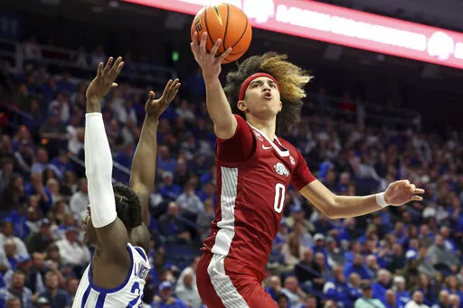 Arkansas' Anthony Black (0) shoots next to Kentucky's Chris Livingston (24) during the second half of an NCAA college basketball game in Lexington, Ky., Tuesday, Feb. 7, 2023. Arkansas won 88-73. (AP Photo/James Crisp)
