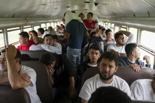 Honduran migrants who were deported from the U.S. sit on a bus after arriving at Ramon Villeda Morales Airport, in San Pedro Sula, Honduras, Wednesday, Dec. 4, 2024. (AP Photo/Moises Castillo)