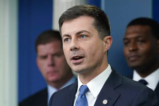 Transportation Secretary Pete Buttigieg, center, speaks during a briefing at the White House in Washington, May 16, 2022, as Labor Secretary Marty Walsh, left, and Environmental Protection Agency administrator Michael Regan, right, listen. Buttigieg says he is pushing airlines to hire more customer-service people and take other steps to help travelers this summer. (AP Photo/Susan Walsh, File)